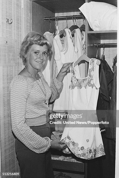 English tennis player Sue Barker pictured holding a tennis dress in a hotel bedroom on 21st June 1976.