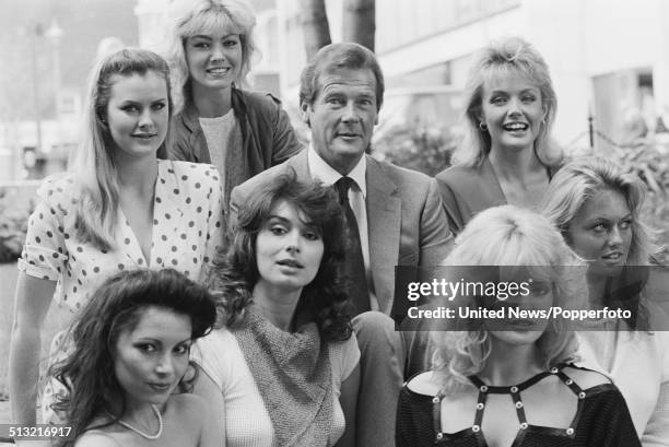 English actor Roger Moore posed with Bond girls Joni Flynn, Janine Andrews, Carole Ashby, Carolyn Seaward, Alison Worth, Mary Stavin and Tina...