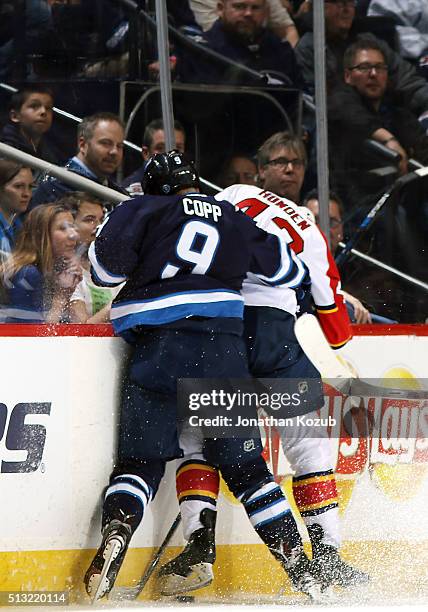 Andrew Copp of the Winnipeg Jets checks Quinton Howden of the Florida Panthers into the boards during first period action at the MTS Centre on March...