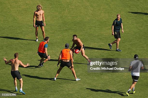 Jobe Watson looks ahead with the ball as Sean Wellman monitors the players during a training session at St.Bernard's College on March 2, 2016 in...