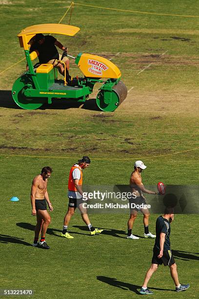 Jobe Watson Michael Hurley and Ben Howlett walk off as Sean Wellman monitors the players during a training session at St.Bernard's College on March...