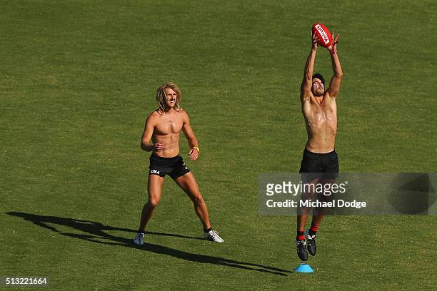 Jobe Watson marks the ball next to Dyson Heppell of the Bombers during a training session at St.Bernard's College on March 2, 2016 in Melbourne,...