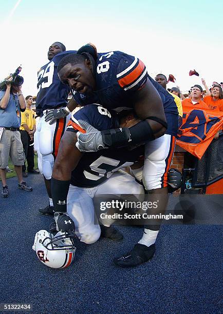 Jay Ratliff of the Auburn Tigers helps teammate Tommy Jackson to the locker room after deafeating the LSU Tigers in a game on September 18, 2004 at...