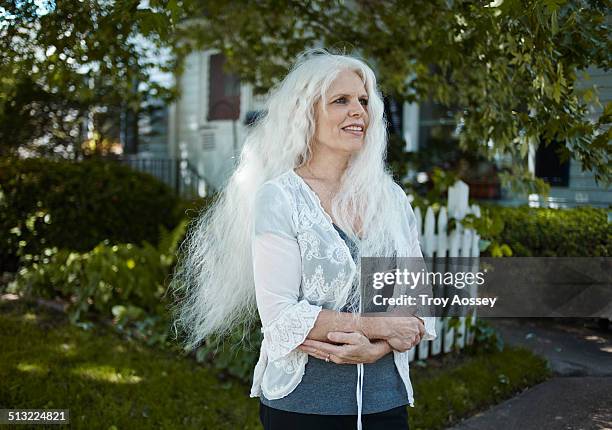 aging woman with long white hair standing outdoors - cedar rapids photos et images de collection