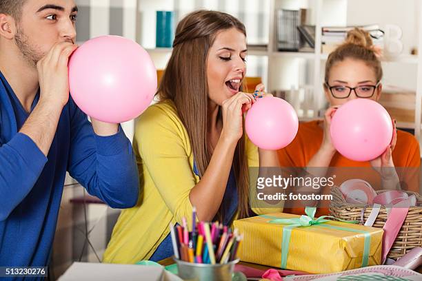 friends blowing up balloons - political party stock pictures, royalty-free photos & images