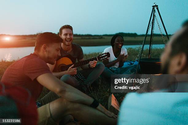 freunde zusammen camping in der natur - brand on guitar stock-fotos und bilder