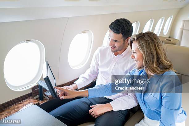 paar mit dem flugzeug reisen und genießen an bord unterhaltung - first class plane stock-fotos und bilder