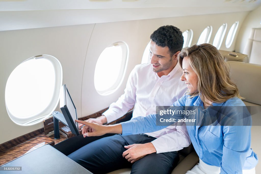 Couple traveling by plane and enjoying onboard entertainment