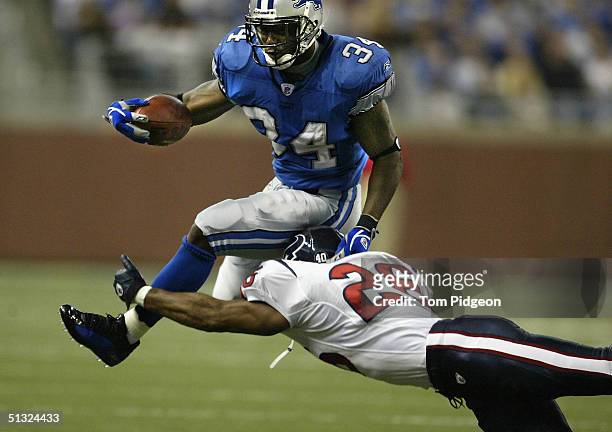 Kevin Jones of the Detroit Lions leaps to avoid Glenn Earl of the Houston Texans at Ford Field on September 19, 2004 in Detroit, Michigan. The Lions...