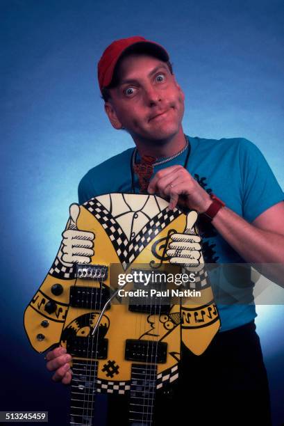 Portrait of American musician Rick Nielsen, of the band Cheap Trick, as he poses with one of his guitars at the Poplar Creek Music Theater, Chicago,...
