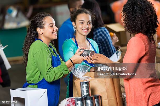 woman donates canned goods to charity - donation box stock pictures, royalty-free photos & images
