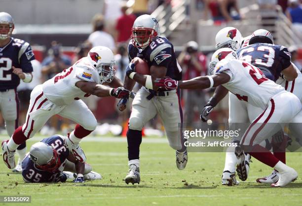 Running back Corey Dillon of the New England Patriots runs with the football between Ronald McKinnon and Adrian Wilson of the Arizona Cardinals at...