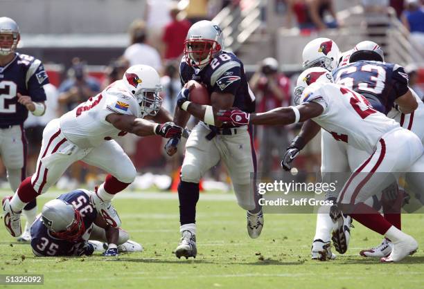 Running back Corey Dillon of the New England Patriots runs with the football between Ronald McKinnon and Adrian Wilson of the Arizona Cardinals at...