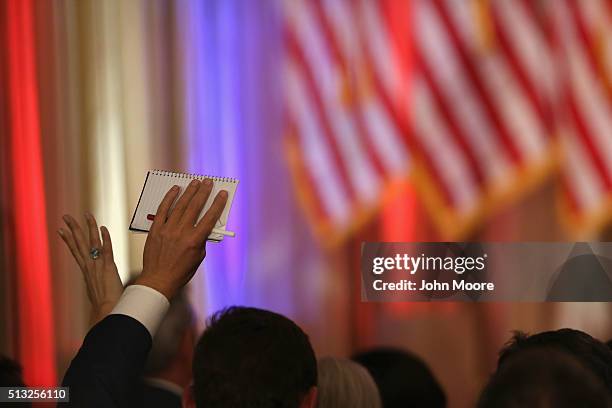 Reporters raise their hands to question Republican Presidential frontrunner Donald Trump at his Mar-A-Lago Club on Super Tuesday, March 1, 2016 in...