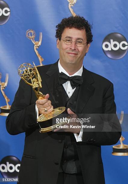 Writer Tony Kushner, winner for Outstanding Writing for a Miniseries, Movie or a Dramatic Special, poses with his Emmy backstage during the 56th...