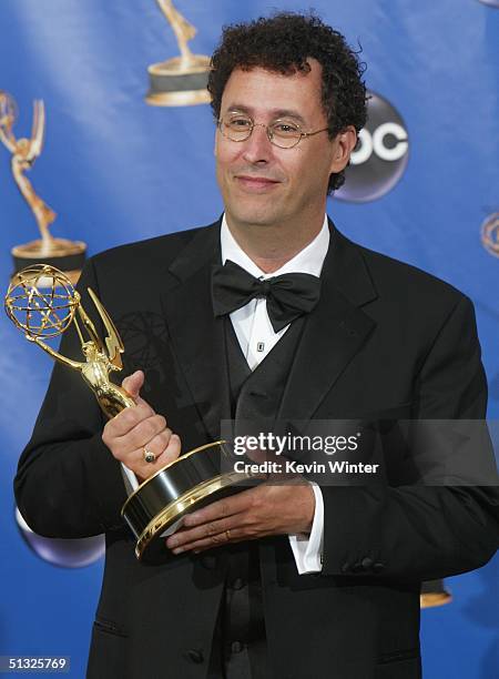 Writer Tony Kushner, winner for Outstanding Writing for a Miniseries, Movie or a Dramatic Special, poses with his Emmy backstage during the 56th...