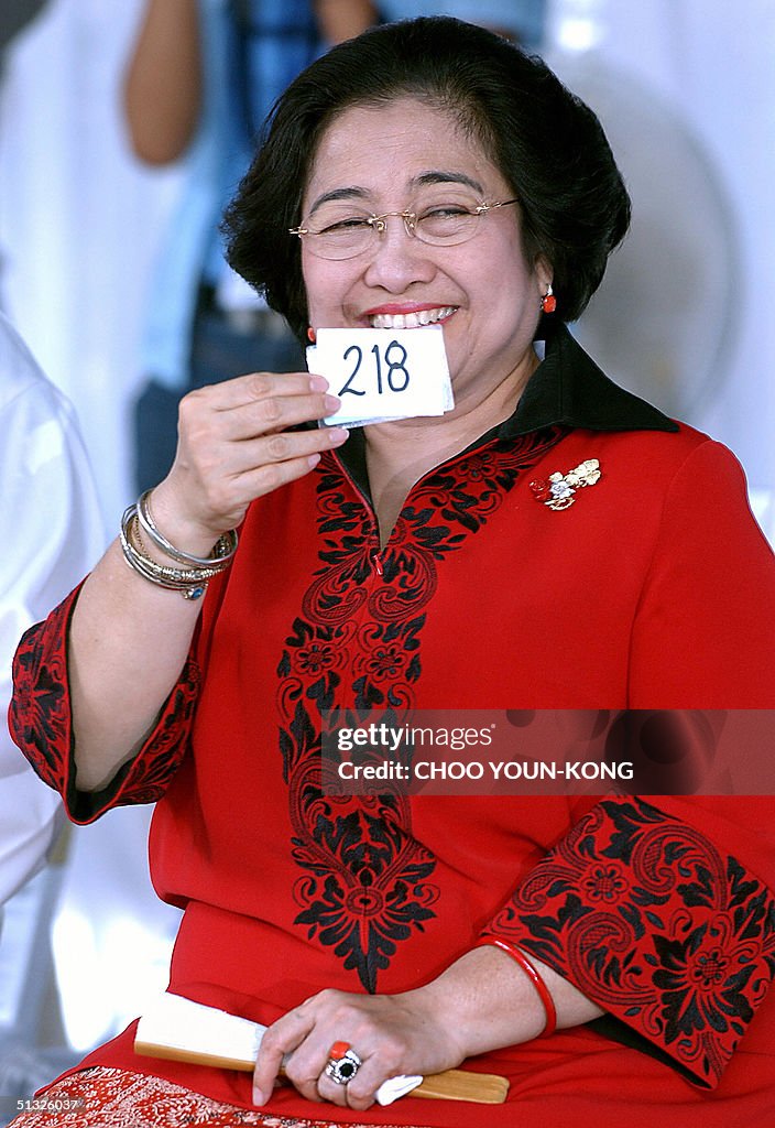 Indonesian President Megawati Sukarnoputri smiles as she shows her ...
