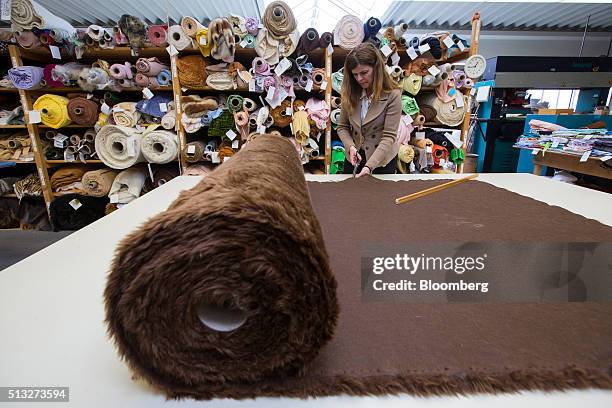 An employee uses scissors to cut fabric in a storage room inside the Steiff GmbH stuffed toy factory in Giengen, Germany, on Tuesday, March 1, 2016....