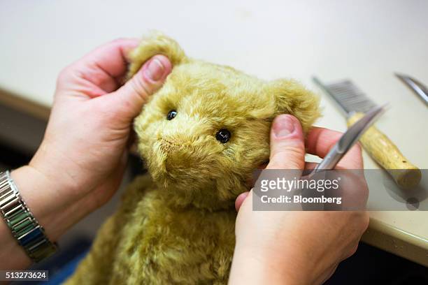 An employee secures eyes to a teddy bear during stuffed toy manufacture inside the Steiff GmbH factory in Giengen, Germany, on Tuesday, March 1,...