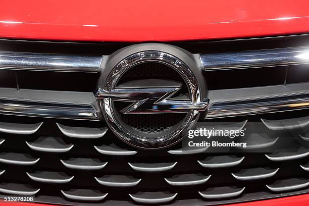 An Opel badge sits on the grille of an Opel Astra automobile, produced by General Motors Co. , sits on display on the second day of the 86th Geneva...