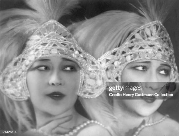 Wearing jewelled and feathered headdresses, twin sisters, Jenny and Rosie Dolly , circa 1918. A famous singing act they starred in 'The Million...