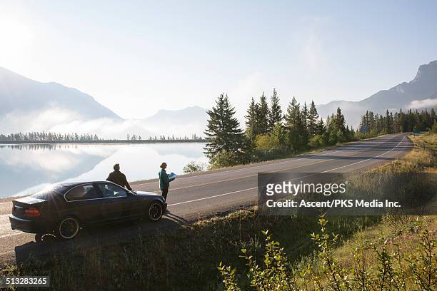 couple relax, look at map on mountain road - road map stockfoto's en -beelden