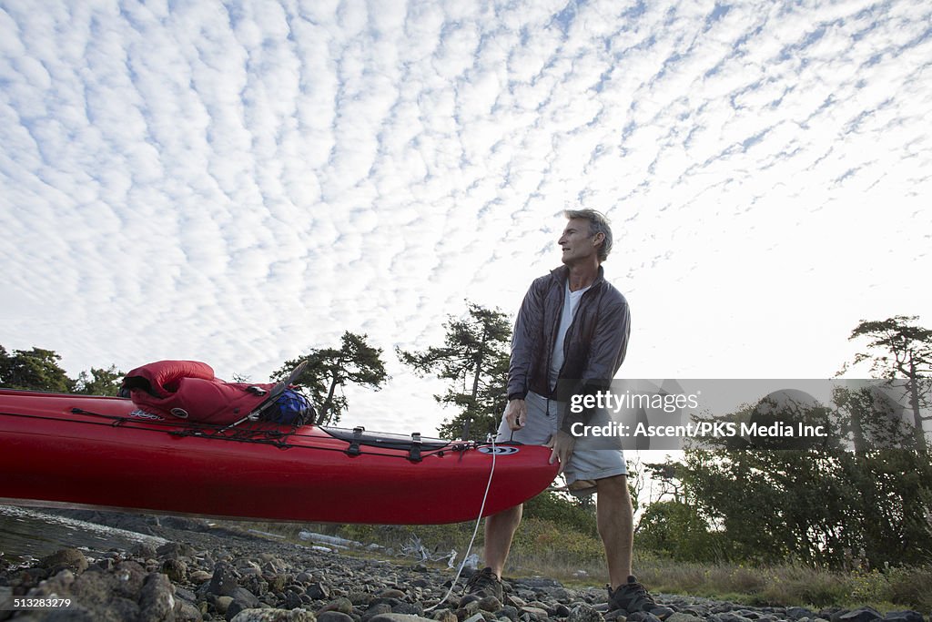 Kayaker prepares to push out form rocky beach