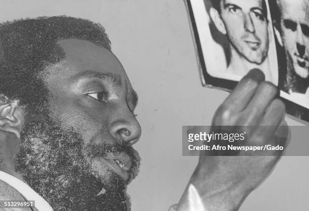 Writer and social activist Dick Gregory holding a picture of Lee Harvey Oswald at Morgan State University, Baltimore, Maryland, September 25, 1975.