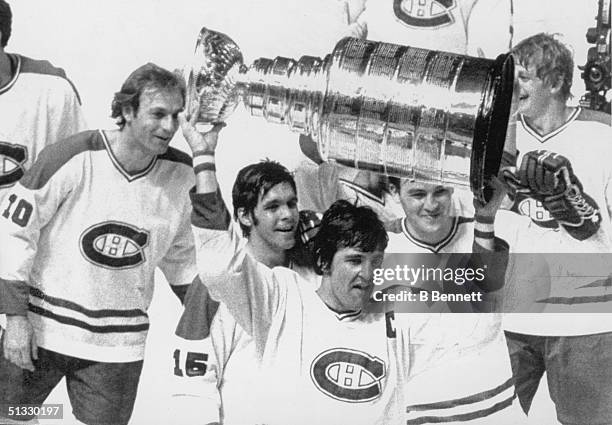 Guy Lafleur, Rejean Houle, Serge Savard, Rick Chartraw and Pierre Mondou of the Montreal Canadiens celebrate as they follow team captain Serge Savard...