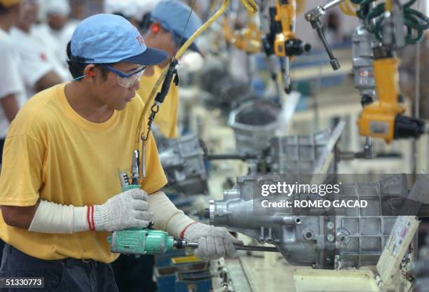 Filipino workers at the Toyota Autoparts Philippines assembles transmission at their manufacturing plant in Santa Rosa, south of Manila 21 September...