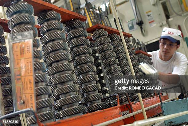 Filipino worker at the Toyota Autoparts Philippines checks transmission parts at their manufacturing plant in Santa Rosa, south of Manila 21...