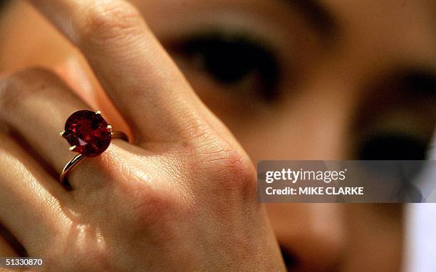 Model Kathy Chow poses with an 8.03 carat oval-cut Burmese ruby ring by Etcetera valued at 8.7 million and12 million HK Dollars at Christie's, in...