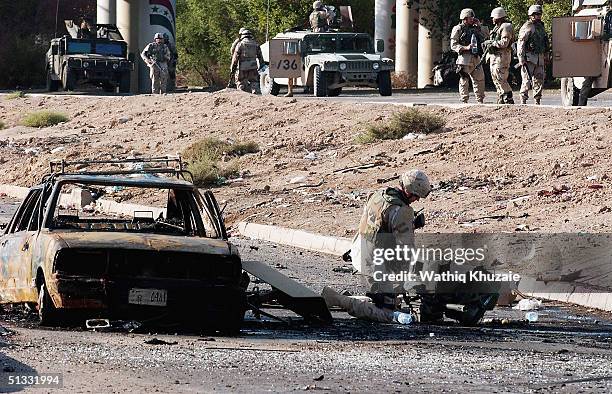 Soldier investigates at the scene of a car bomb explosion on September 21, 2004 in Baghdad, Iraq. A car bomb exploded near a US military convoy...