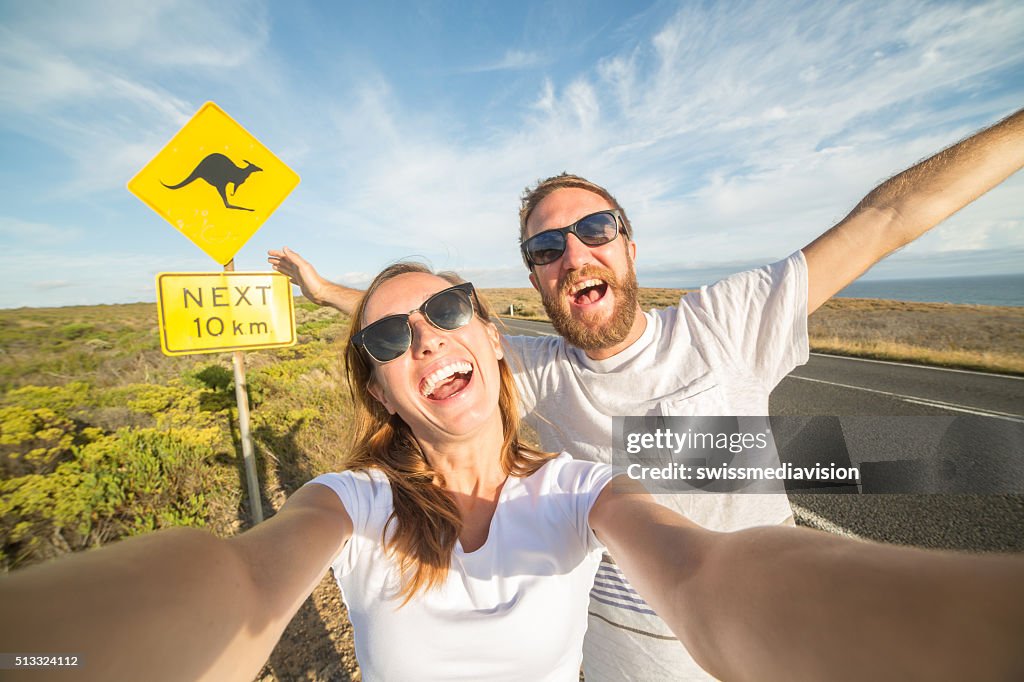 Jovem Casal tirar uma selfie Retrato perto de sinal de aviso de canguru na Austrália