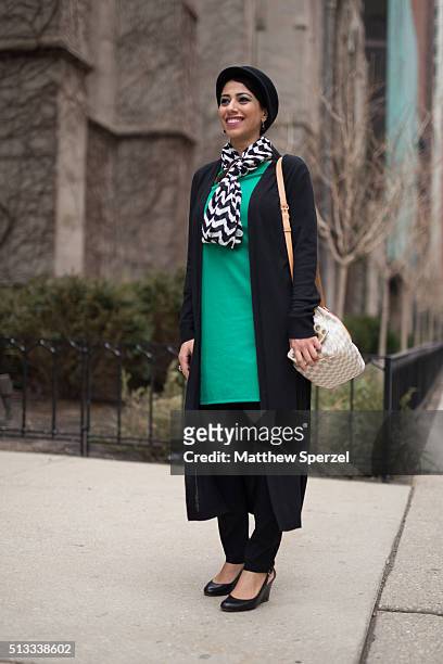 Dena Suhil is seen on Michigan Avenue wearing a Calvin Klein hat, Black & White Market black coat, Charming Charlie black & white scarf and green...