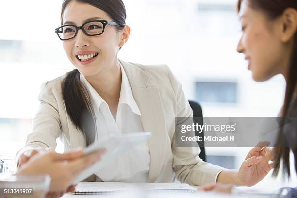 business women at a table having a meeting - michael virtue stock pictures, royalty-free photos & images