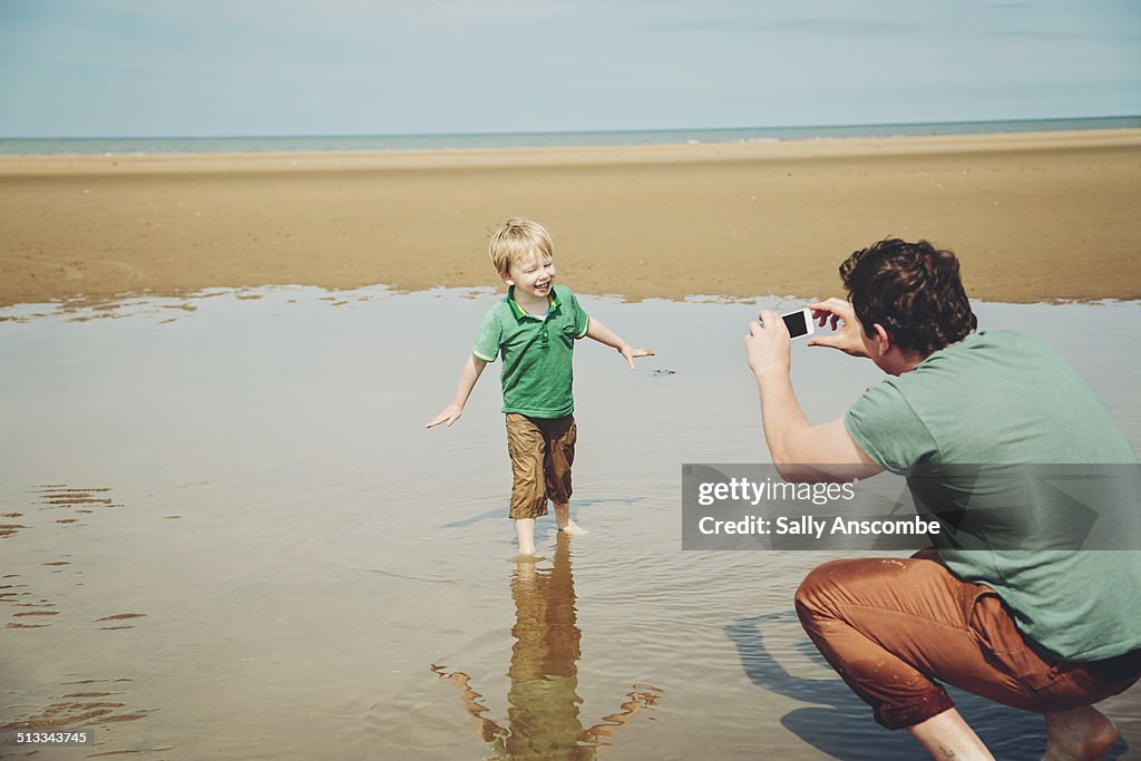 Father taking a photo of his son