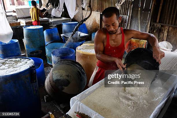 Man making "Tahu" in a small processing shop. Tahu is Indonesian traditional food made from soy. It is a healthy food containing vegetable protein...