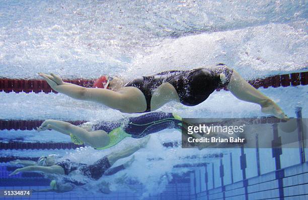 Christina Heer of Switzerland and Lichelle Clarke of Australia dive off the start for the Womens 100m Backstroke swimming on September 22, 2004...