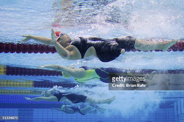 Christina Heer of Switzerland and Lichelle Clarke of Australia dive off the start for the Womens 100m Backstroke swimming on September 22, 2004...