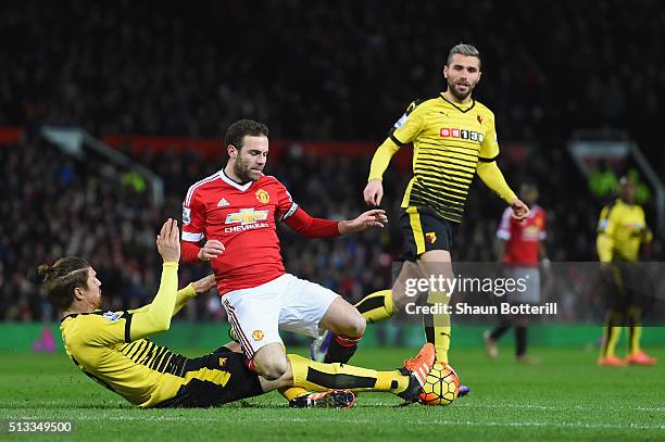 Sebastian Prodl of Watford slides in to tackle Juan Mata of Manchester United during the Barclays Premier League match between Manchester United and...