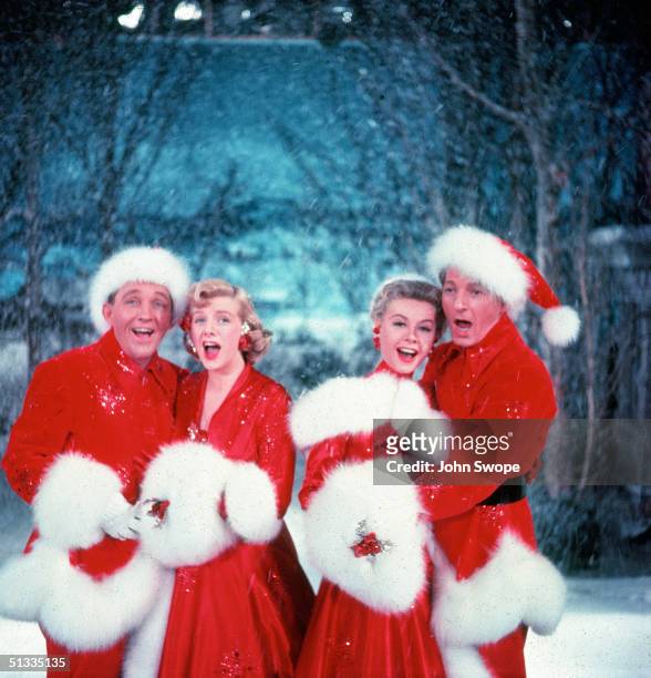 American actors Bing Crosby , Rosemary Clooney , Vera-Ellen , and Danny Kaye sing together, while dressed in fur-trimmed red outfits and standing in...
