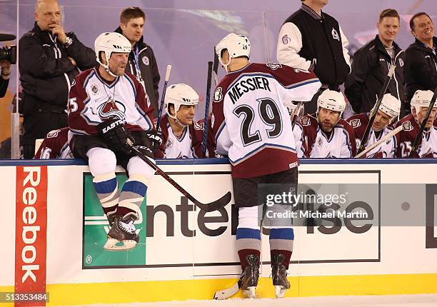 Eric Messier and Shjon Podein of the Colorado Avalanche Alumni team talk on the boards during a break in the action against the Red Wings Alumni team...