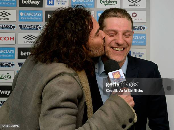 Slaven Bilic of West Ham United is given a kiss by Russell Brand whilst on West Ham TV after the Barclays Premier League match between West Ham...