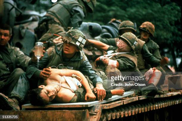 Several bloody and bandaged soldiers ride on top of a tank used as a make-shift ambulance after the Battle of Hue in the Vietnam War, Hue, Vietnam,...