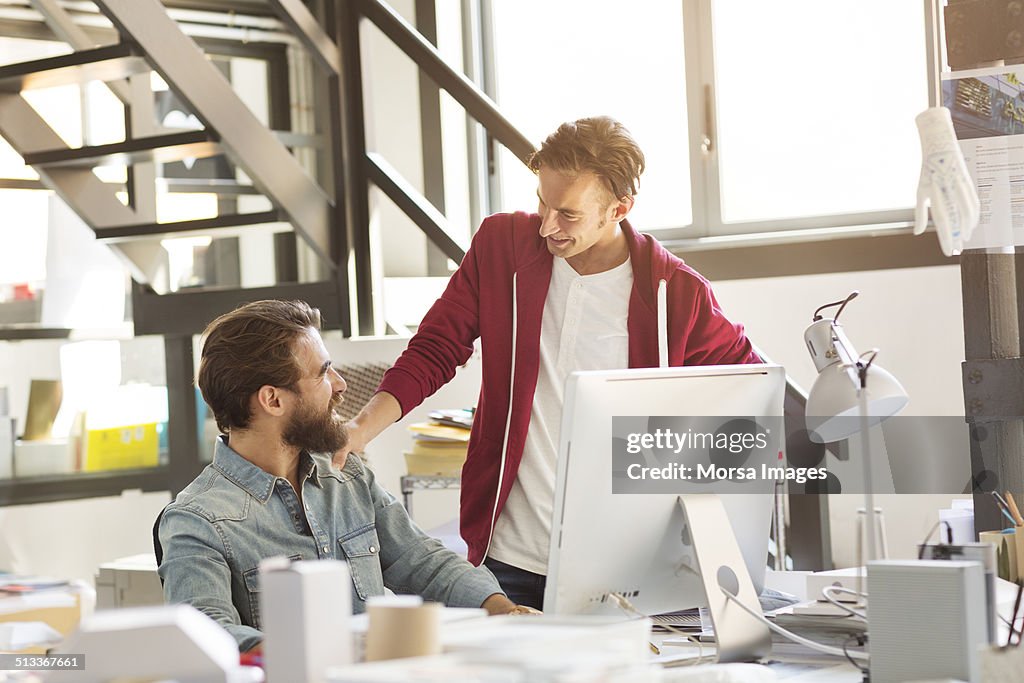 Businessmen discussing at desk in office