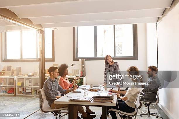 business people discussing in board room - mann am tisch mit papier stock-fotos und bilder