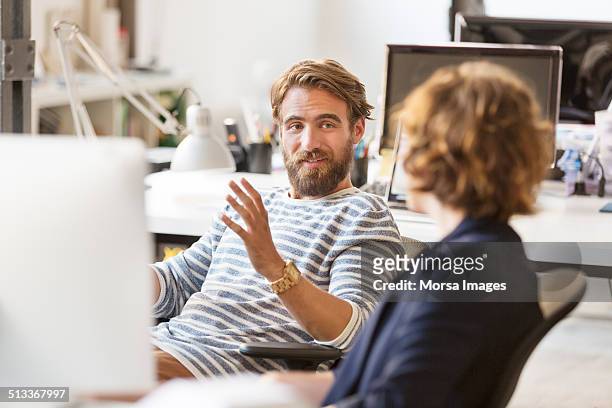 businessman discussing with colleague in office - 2 men chatting casual office stockfoto's en -beelden