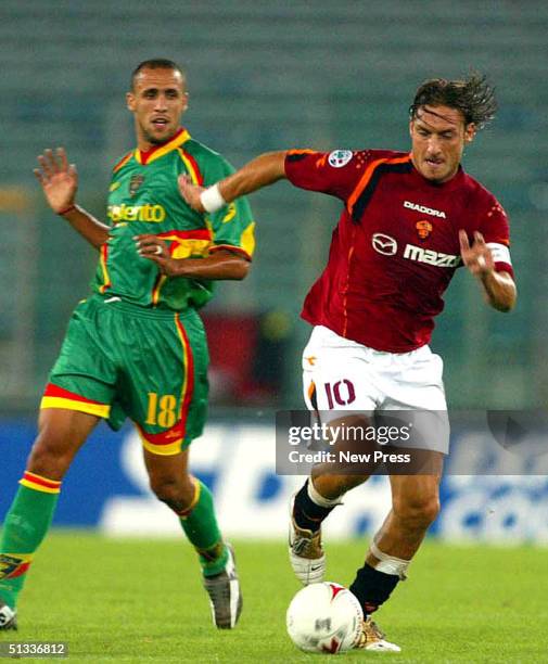 Francesco Totti of Roma moves the ball past Guillermo Giacomazzi of Lecca during the Italian Serie A match between Lecce v Roma September 22, 2004 at...