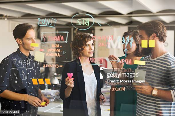 business people discussing over plan - cooperazione foto e immagini stock